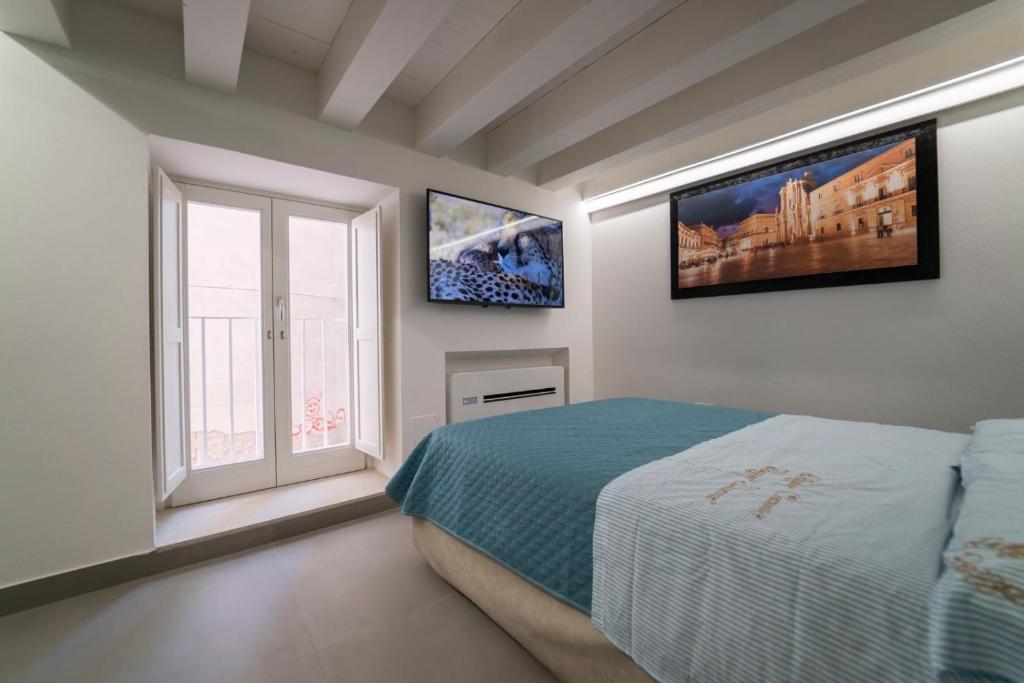 锡拉库扎Ortigia Charme piazza Duomo的一间卧室设有一张床和一个窗口