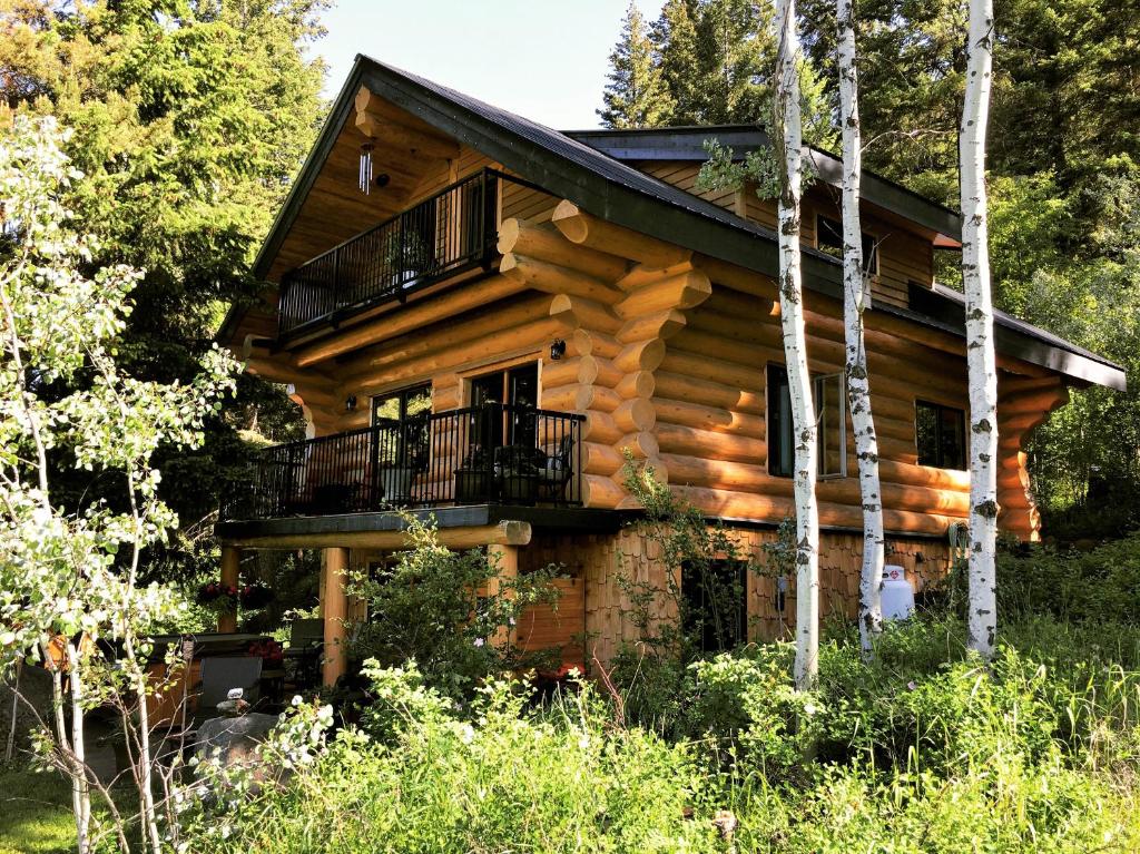 太阳峰A Suite Retreat - Beyond Bed & Breakfast的树林中的小木屋 - 带阳台