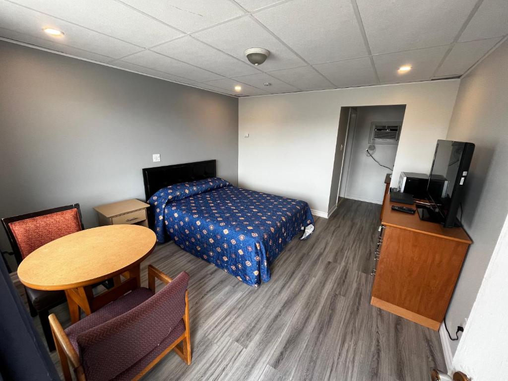 康沃尔伊莱科特旅5号旅馆的配有床、桌子和电视的房间