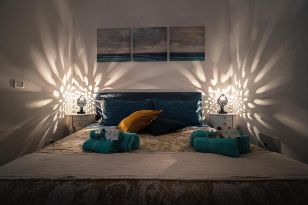 锡拉库扎La Casetta del Ronco1 Ortigia的一间卧室配有一张大床,两盏灯