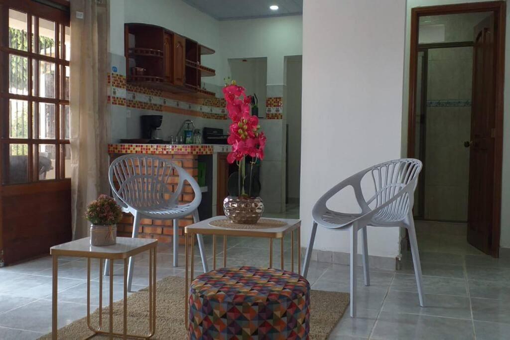 莱蒂西亚Hermoso y cómodo apartamento en Leticia的厨房配有两把椅子和一张鲜花桌
