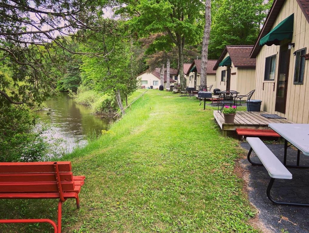 BenzoniaBetsie Riverside Resort的河边的一排桌子和长椅
