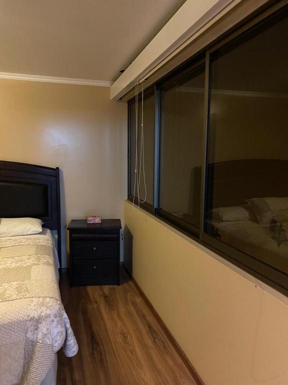 安托法加斯塔CASA VILLA AZUL 3 PISOS的一间卧室设有一张床和一个大窗户