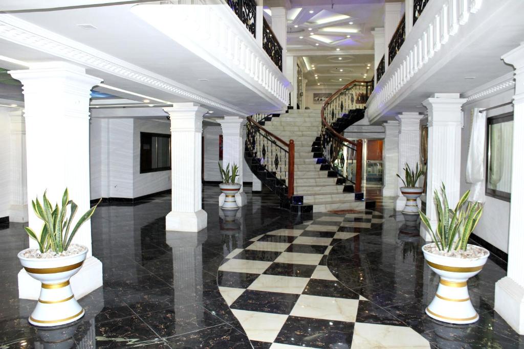 科托努RESIDENCE PALAIS DU STADE的大堂设有黑白格子地板和楼梯