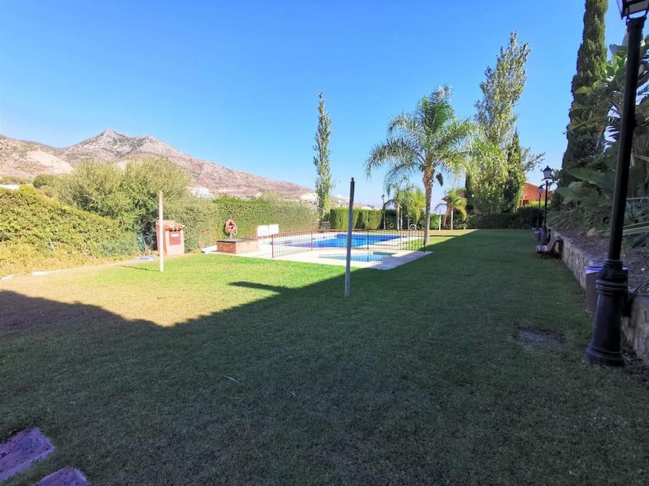贝纳尔马德纳casa pareada espectacular的一个带游泳池和棕榈树的庭院