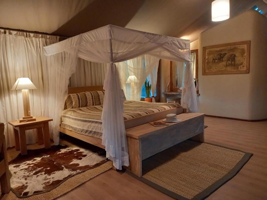 塔勒克Mara Maisha Camp的一间卧室配有一张带天蓬的床