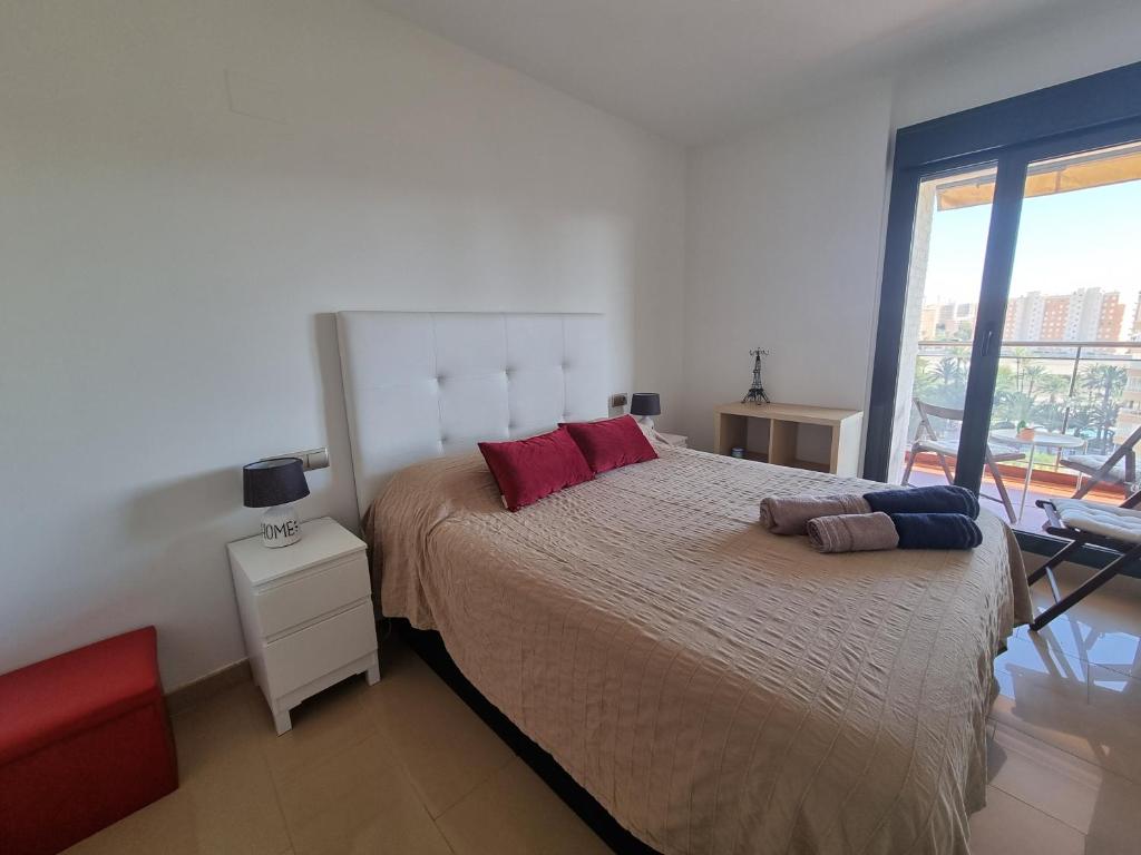 阿利坎特Apartamento con vistas al mar的一间卧室配有一张大床和红色枕头