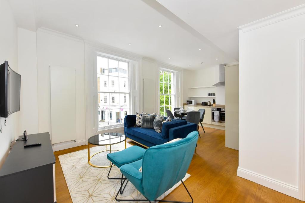 伦敦London Choice Apartments - Chelsea - Sloane Square的客厅配有蓝色的沙发和桌子