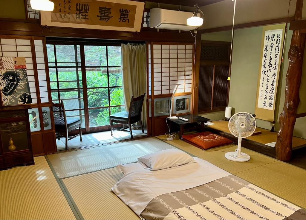 奈良奈良町宾馆的客房设有一张床和风扇。