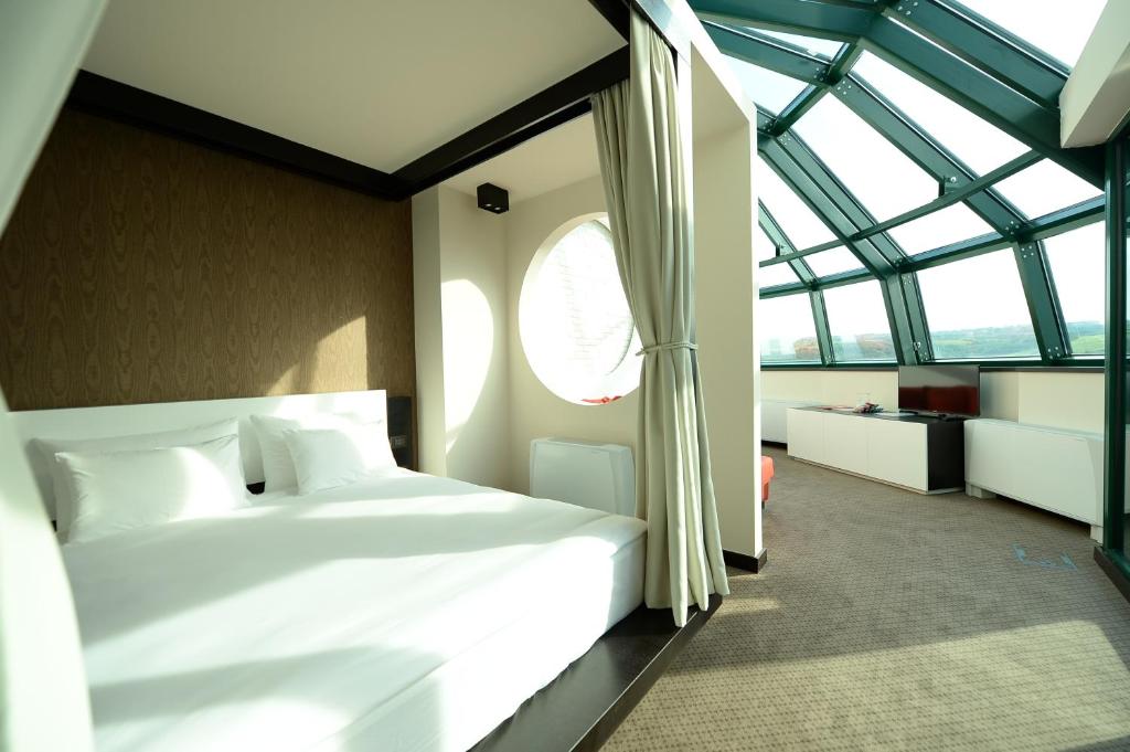 贝尔格莱德享乐酒店的卧室设有一张白色大床和一扇窗户。