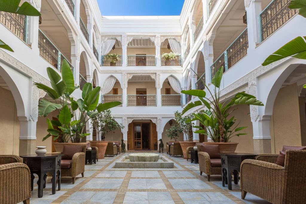 阿加迪尔布兰奇别墅摩洛哥传统庭院住宅酒店的大堂设有喷泉、椅子和植物