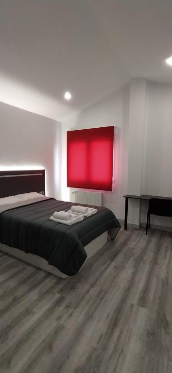 桑坦德ALOJAMIENTOS AVICHE 6的一间卧室设有一张床和红色的墙壁