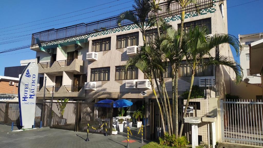 瓜拉图巴Hotel Nautico的前面有棕榈树的建筑