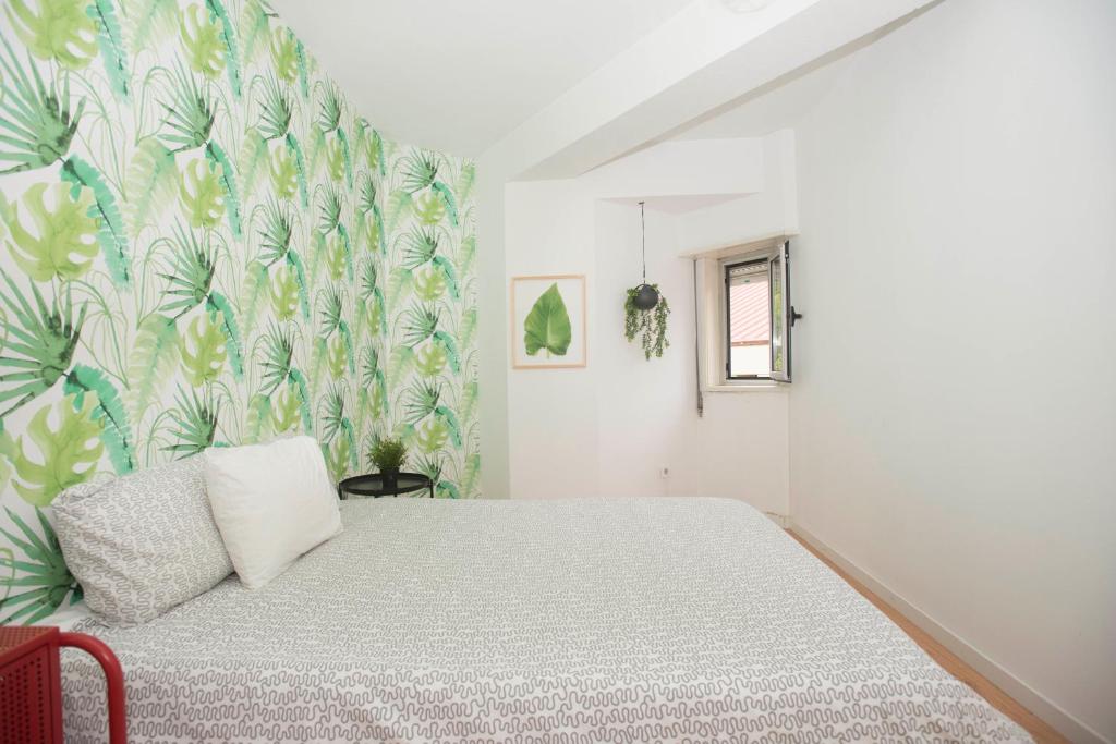 波尔图Travel & Live Marques的一间卧室配有一张床和花卉壁纸