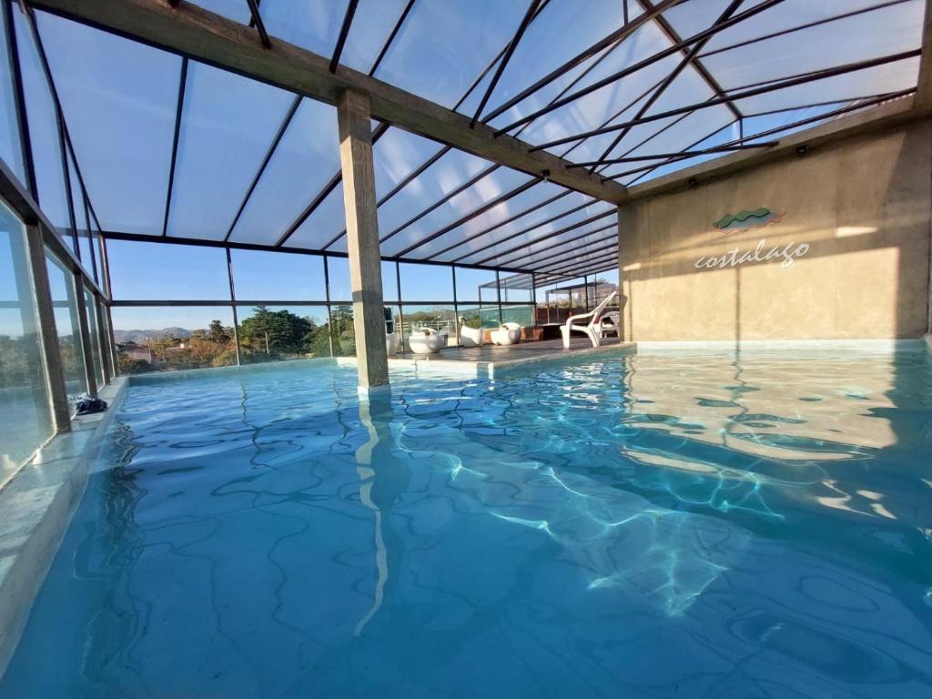 维拉卡洛斯帕兹Costalago Suites的一个带玻璃天花板的大型室内游泳池
