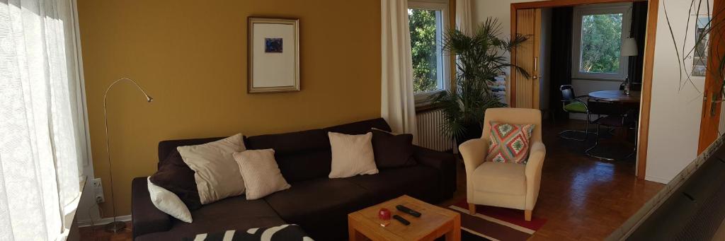 奥尔登堡Stadtnahe Wohnung mit kl.Balkon und Parkplatz的客厅配有黑色沙发和椅子
