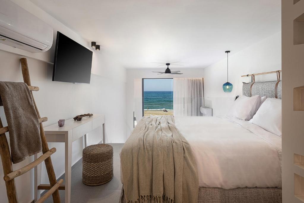 罗希姆诺Calla Luxury Seafront Suites的一间卧室配有一张床,享有海景