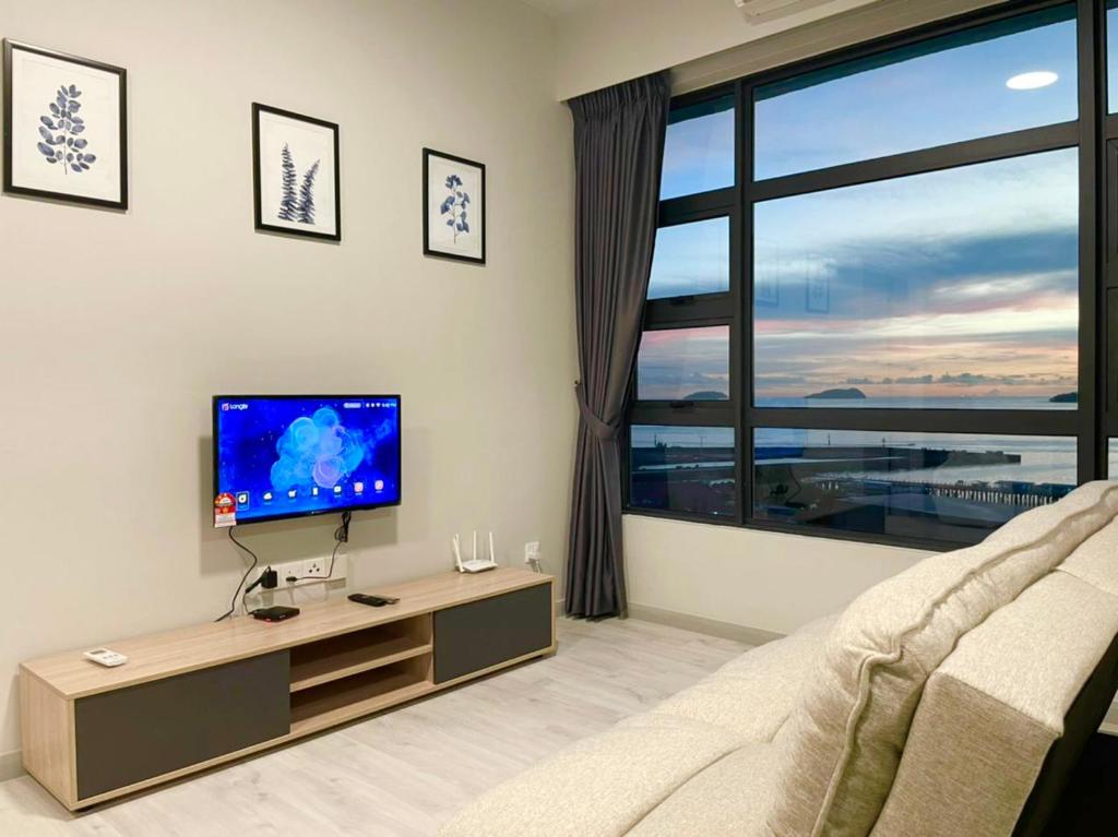 哥打京那巴鲁Sunset Seaview Vacation Condos @ Jesselton Quay的一间带电视和大窗户的客厅