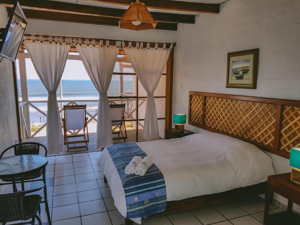 奇卡马港Delfines de Chicama Hotel的一间卧室配有一张床,享有海景