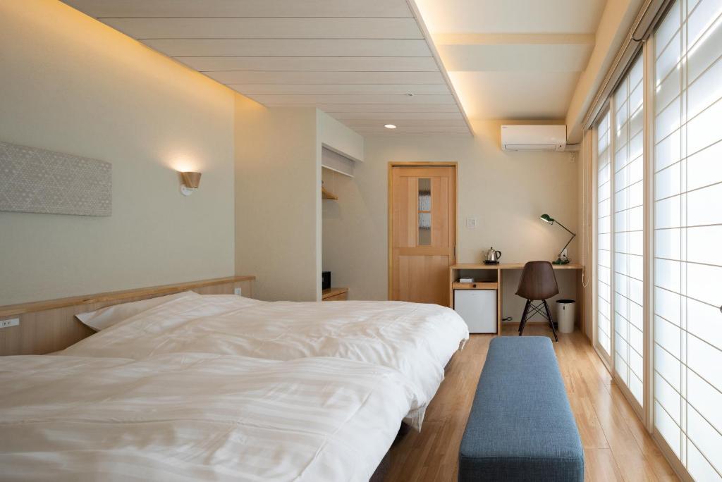 神户Arima Koyado Uraku的卧室配有白色的床和蓝色地毯。