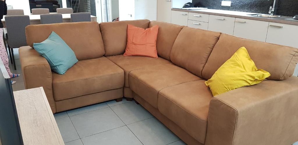 胡塔伦Ceder 104的棕色的沙发上配有4个色彩缤纷的枕头