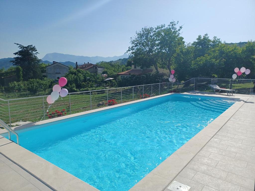 Montefalcone AppenninoLe Margherite Country House的一座带气球的大型蓝色游泳池,位于一个院子内