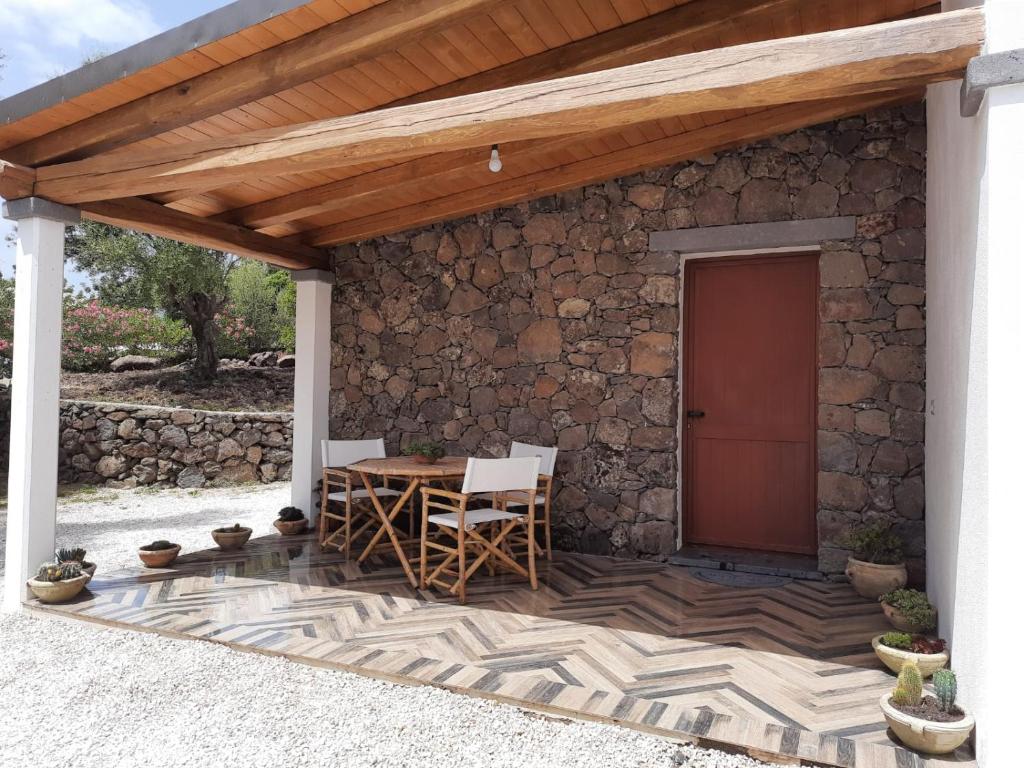 多尔加利Casa Olivastra的一个带桌椅和石墙的庭院