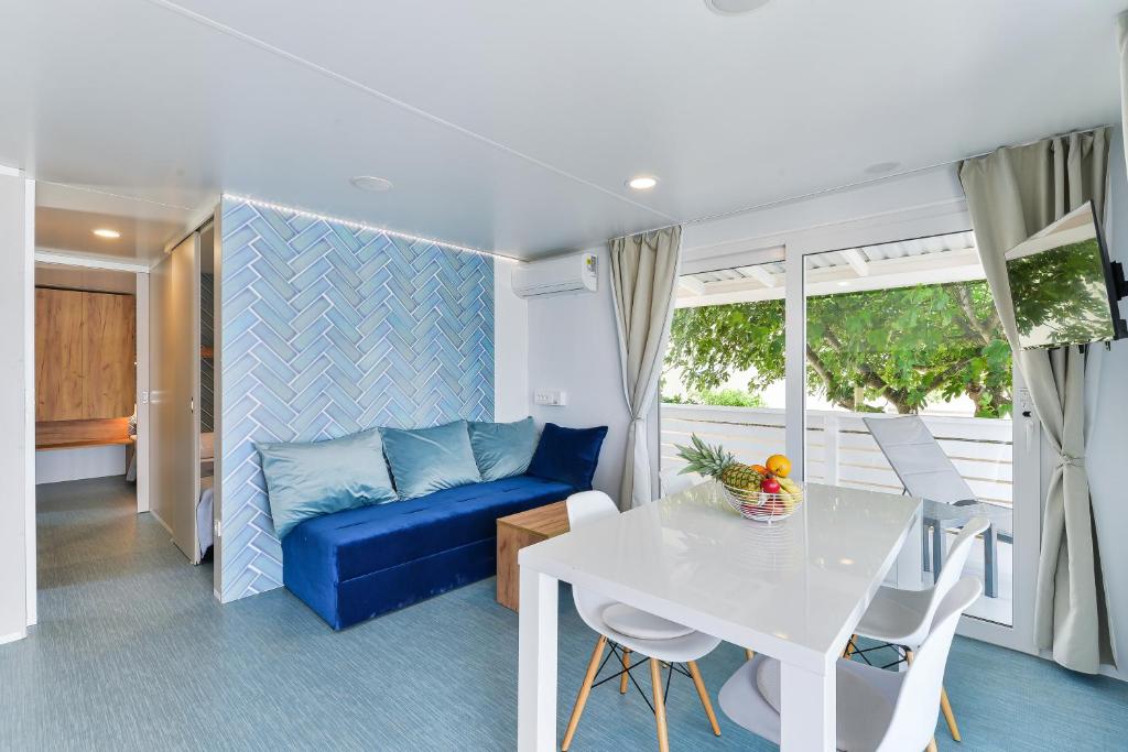 图兰杰Adria Nova kamp Laguna的客厅配有蓝色的沙发和桌子