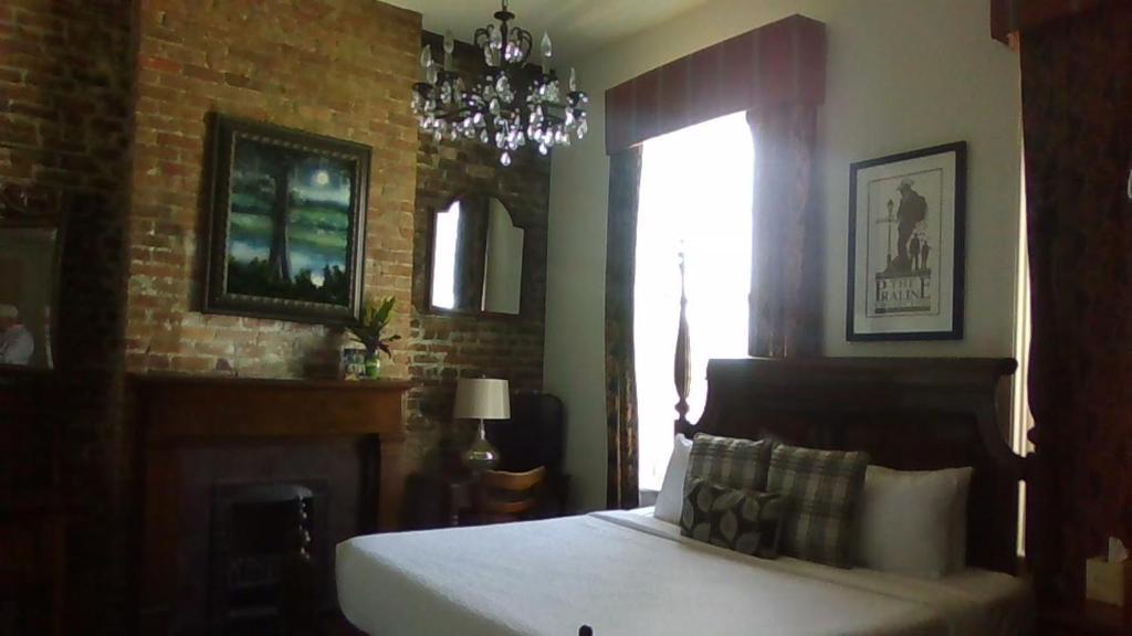新奥尔良Lafitte Hotel & Bar的一间卧室设有一张床和砖墙