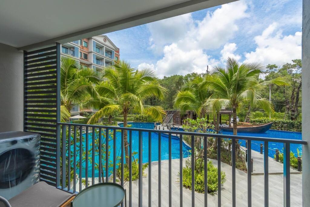 奈扬海滩Title Naiyang residence Excellent location with pool view的享有游泳池和棕榈树景致的阳台