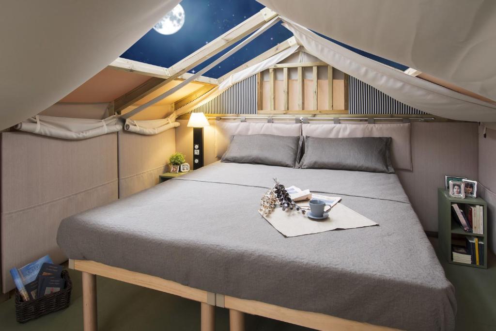 博尔塞纳Blu International Camping的一张大床,位于一个小房间里,配有桌子
