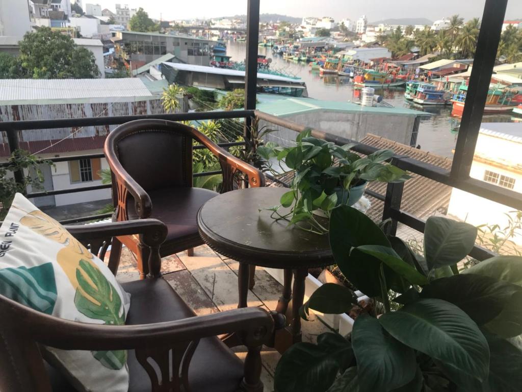 富国Nhà nghỉ Phương Dung的阳台配有桌椅,享有海港的景致。