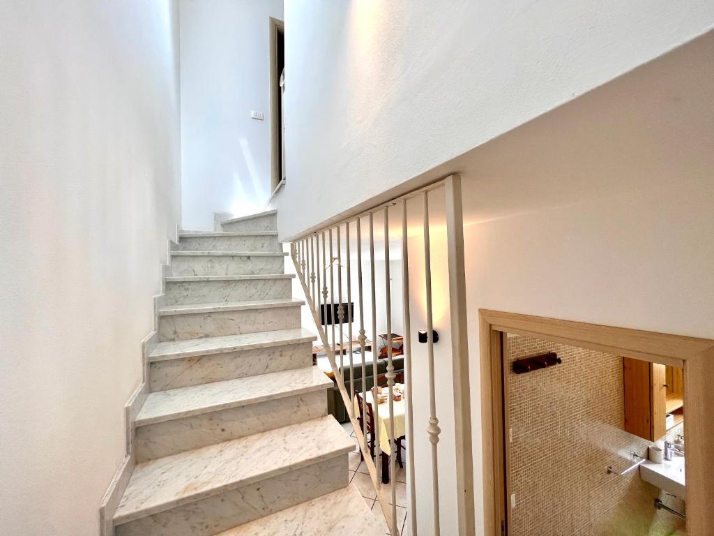 卡拉拉Luminoso appartamento indipendente, al mare !的白色墙壁的房屋内的楼梯