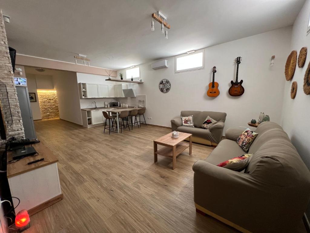 斯佩基亚Tavernetta Open space的客厅配有沙发和墙上的吉他