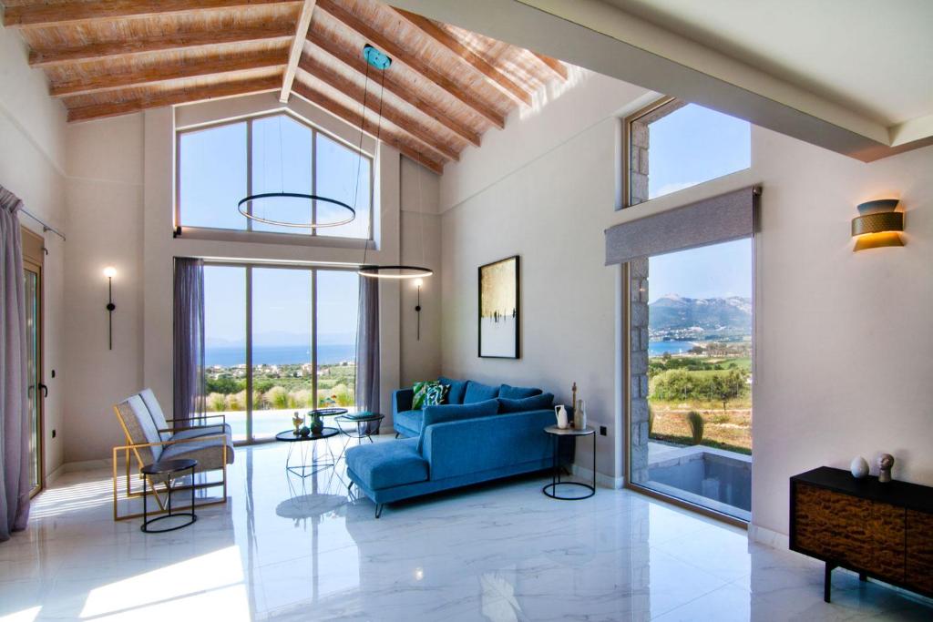 帕莱罗斯Villas Mandalos的客厅设有蓝色的沙发和大窗户