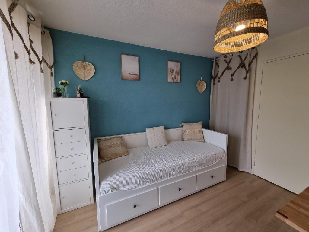 勒格罗-迪鲁瓦Studio cabine refait à neuf à 3 minutes à pied de la plage的卧室配有白色的床和蓝色的墙壁