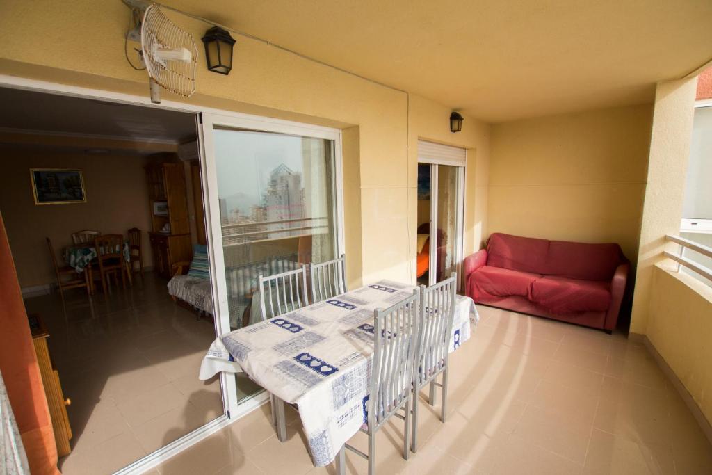 卡拉德费斯特拉特Bonito apartamento cerca de la playa, planta alta.的客厅配有桌子和红色沙发