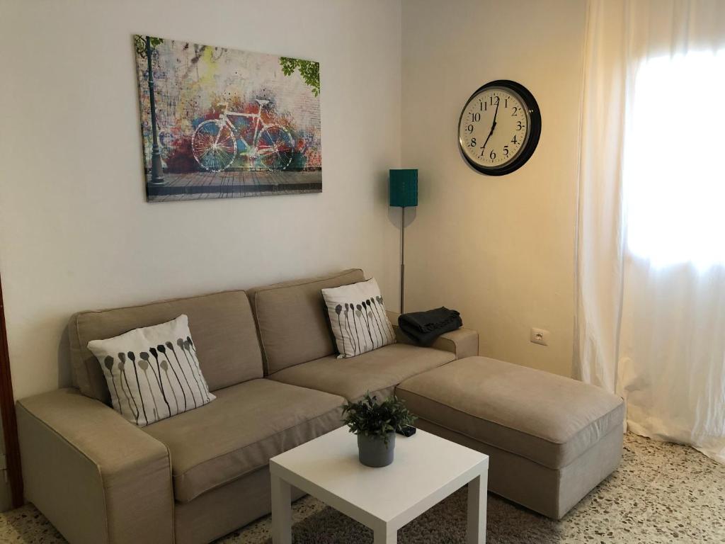 拉拉古纳Exclusive Las Gavias的客厅配有沙发和墙上的时钟