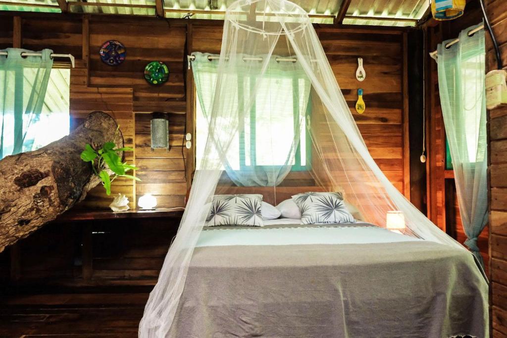 卡维塔Playa Grande Lodge & Tree House的配有蚊帐的客房内的一张床位