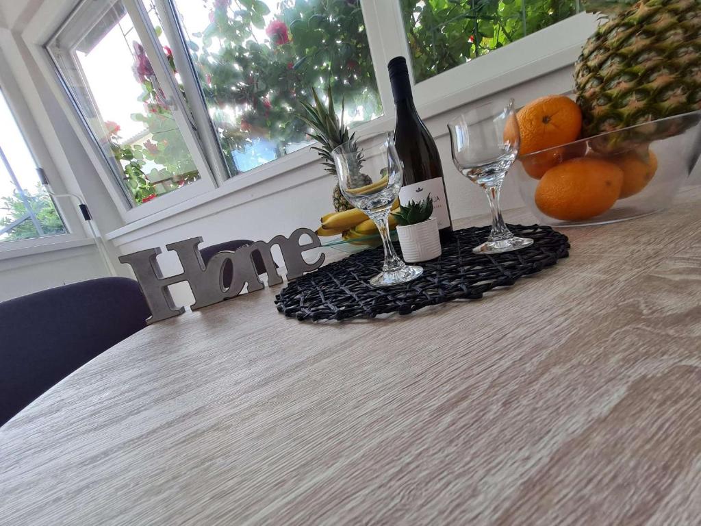 扎达尔Apartmani Lovre i Zara的一张桌子,上面放有酒杯和水果