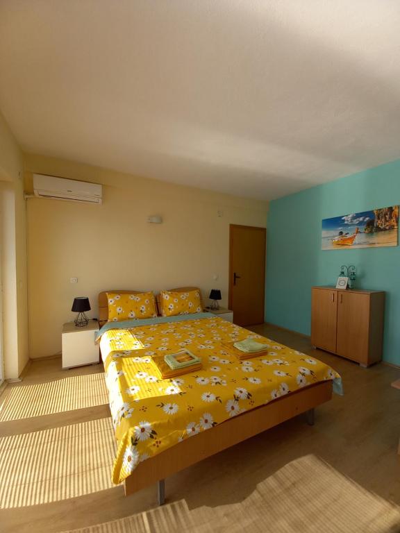 佩斯塔尼PS Apartments - Peshtani的一间卧室配有一张带黄色毯子的大床