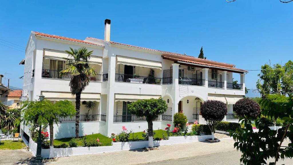 埃尔莫奈斯Villa Deza的一座白色的建筑,前面有棕榈树