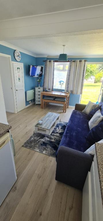 桑当Isle of Wight Chalet的客厅配有沙发和桌子