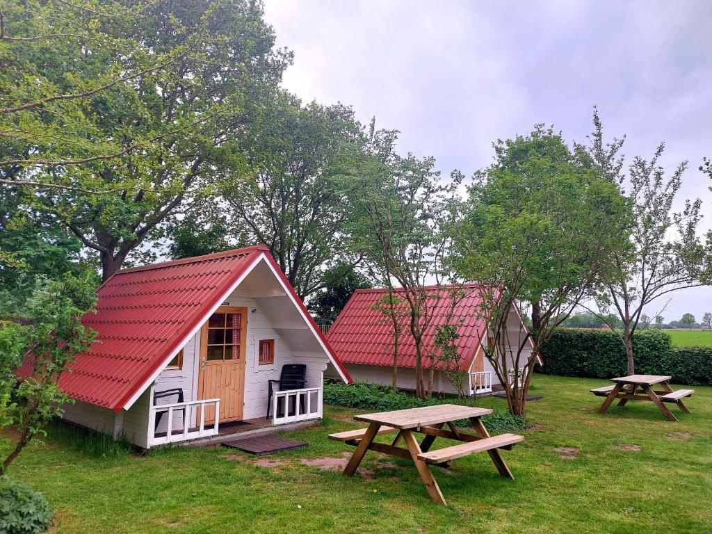 WeddeSlaaphutje BuitenWedde Westerwolde的小屋设有红色屋顶和野餐桌