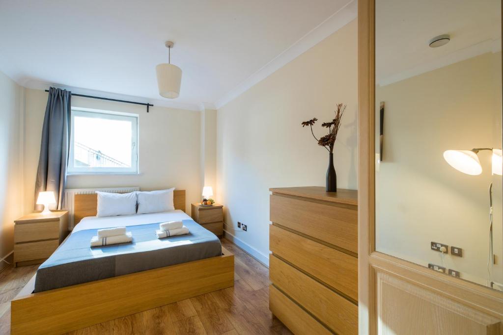 伦敦Royal London Apartments的带床和窗户的卧室