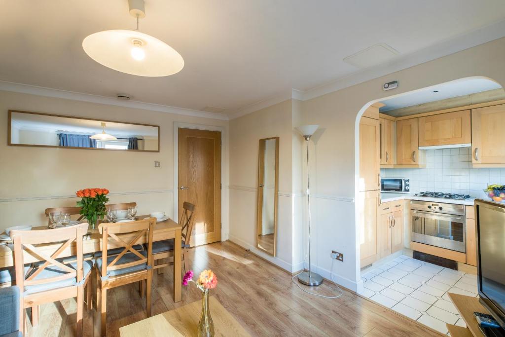 伦敦Royal London Apartments的厨房、带桌子的用餐室和用餐室