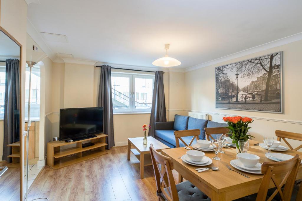 伦敦Royal London Apartments的客厅里有一张桌子和一张蓝色沙发