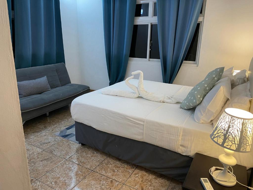 Pointe LarueMARL自助式酒店的一间卧室配有床、沙发和蓝色窗帘