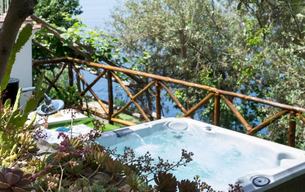 普莱伊亚诺Residence Lì Galli的阳台上的按摩浴缸,带有木栏杆