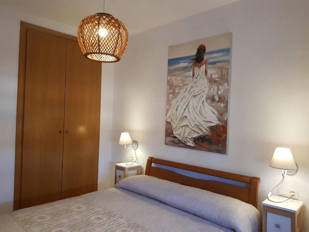 奥罗佩萨德尔马Marina dor Frontal 1ª línea的卧室配有一张床,墙上挂有绘画作品